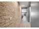 Hallway with a decorative brick wall detail leading to the bright living space at 26141 N 133Rd Ave, Peoria, AZ 85383