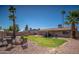 Backyard featuring manicured lawn, desert landscaping, fire pit, outdoor grill and mature palm trees at 307 W Piute Ave, Phoenix, AZ 85027