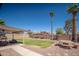 Expansive backyard featuring desert landscaping, mature palms, covered patio and outdoor seating area at 307 W Piute Ave, Phoenix, AZ 85027