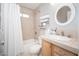 Bright bathroom featuring a shower over tub, tan tile and a modern sink with updated fixtures at 307 W Piute Ave, Phoenix, AZ 85027