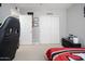 Neat and organized bedroom featuring a bed with a red comforter, a gaming chair, and closet doors at 307 W Piute Ave, Phoenix, AZ 85027