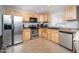 Modern kitchen featuring stainless steel appliances, natural wood cabinets, and tile flooring at 307 W Piute Ave, Phoenix, AZ 85027