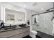 Modern bathroom featuring dual sinks, a large mirror, and a walk-in shower with marble tile at 3707 E Amelia Ave, Phoenix, AZ 85018