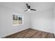 This bedroom is filled with natural light from a large window, highlighting wood floors and neutral wall color at 3707 E Amelia Ave, Phoenix, AZ 85018