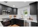 Modern kitchen features dark cabinetry, stainless steel appliances and a marble backsplash and countertops at 3707 E Amelia Ave, Phoenix, AZ 85018