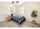 Comfortable bedroom with plank floors, a single bed with blue bedding, and bright natural light at 3719 E Longhorn St, San Tan Valley, AZ 85140