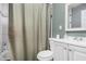 Cozy bathroom with a toilet, vanity, shower with curtain, and green walls at 3913 W Sherman St, Phoenix, AZ 85009