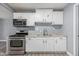 Efficient kitchen with stainless steel appliances, white cabinetry, and sleek gray flooring at 3913 W Sherman St, Phoenix, AZ 85009