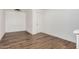 Empty room with wood look floors, white walls, and a white door at 3913 W Sherman St, Phoenix, AZ 85009