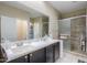A bright bathroom features double sinks with a dark vanity, plus a glass-enclosed shower at 41004 W Crane Dr, Maricopa, AZ 85138