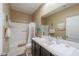 Well-lit bathroom featuring a shower-over-tub with a large mirror and ample counter space at 41004 W Crane Dr, Maricopa, AZ 85138