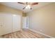 Bedroom with a ceiling fan, wood-look laminate flooring, and a double door closet at 41004 W Crane Dr, Maricopa, AZ 85138