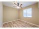 Bright bedroom with a ceiling fan, a window that allows natural light in, and wood-look laminate flooring at 41004 W Crane Dr, Maricopa, AZ 85138