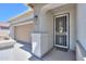 Inviting front entryway with neutral stucco walls, a security door and a two-car garage at 41004 W Crane Dr, Maricopa, AZ 85138