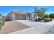 Attractive home with a well-manicured yard and a large driveway leading to an attached two-car garage at 41004 W Crane Dr, Maricopa, AZ 85138