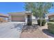 Lovely home with a xeriscape front yard, mature trees, and a two-car garage with a long driveway at 41004 W Crane Dr, Maricopa, AZ 85138