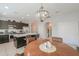 An open-concept kitchen with dark cabinets, a center island, and a view to the breakfast nook at 41004 W Crane Dr, Maricopa, AZ 85138
