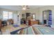 An inviting main bedroom with wood-look flooring, ceiling fan, and a home office area at 41004 W Crane Dr, Maricopa, AZ 85138