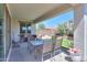 Covered patio featuring table and chairs, with an artificial lawn and plants visible in the background at 41004 W Crane Dr, Maricopa, AZ 85138