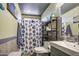 This bathroom features a toilet, sink, decorative shower curtain, and convenient shelving for storage at 4545 N 67Th Ave # 1101, Phoenix, AZ 85033