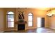 Cozy living room with a fireplace, two arched windows, and sliding glass doors to the outdoor space at 5640 E Bell Rd # 1047, Scottsdale, AZ 85254