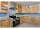 Stylish kitchen boasts stainless steel appliances, granite countertops, and custom backsplash at 5802 N 61St Dr, Glendale, AZ 85301