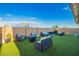 Backyard with artificial lawn, outdoor seating, and a cozy fire pit at 5897 N 195Th Dr, Litchfield Park, AZ 85340
