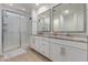 This bathroom features a double sink vanity, granite countertop, and a glass enclosed shower at 5897 N 195Th Dr, Litchfield Park, AZ 85340