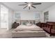 Bright bedroom with a ceiling fan, carpeted floors, large windows, and a comfortable bed with stylish decor at 5897 N 195Th Dr, Litchfield Park, AZ 85340