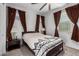This bedroom features a bed with a patterned comforter and two windows with brown curtains at 5897 N 195Th Dr, Litchfield Park, AZ 85340