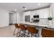 Modern kitchen with stainless steel appliances, tile backsplash, and an island with seating at 5897 N 195Th Dr, Litchfield Park, AZ 85340