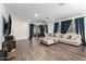 Spacious living room with wood flooring, and sliding glass doors leading to the backyard at 5897 N 195Th Dr, Litchfield Park, AZ 85340