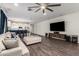 Expansive living room showcasing a stylish sectional, modern lighting, and seamlessly connecting to the kitchen at 5897 N 195Th Dr, Litchfield Park, AZ 85340
