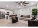 Inviting living area with hardwood floors, ceiling fan, kitchen access, and cozy seating, perfect for relaxation at 5897 N 195Th Dr, Litchfield Park, AZ 85340