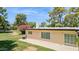 Spacious backyard with a well-kept lawn and the home's exterior with desert landscaping at 6147 E Lewis Ave, Scottsdale, AZ 85257