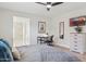 Bedroom with laminate floors, a ceiling fan, desk, TV, and ensuite bath at 6147 E Lewis Ave, Scottsdale, AZ 85257