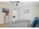 Bright bedroom featuring light hardwood floors, ceiling fan, and a mounted TV at 6147 E Lewis Ave, Scottsdale, AZ 85257