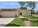 Home exterior featuring an arched gate, stucco wall, a garage, and desert landscaping at 6147 E Lewis Ave, Scottsdale, AZ 85257