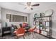 Living room with a gray sofa, orange chairs, and built-in shelves with decor at 6480 N 82Nd St # 1136, Scottsdale, AZ 85250