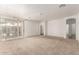 Large living area with neutral carpet and access to a patio through sliding glass doors at 6620 S 16Th Dr, Phoenix, AZ 85041