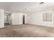 Bright and airy living room featuring neutral carpeting, white walls, and arched doorways at 6620 S 16Th Dr, Phoenix, AZ 85041