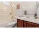 Cozy bathroom features a shower-tub combo and vanity with wooden cabinets at 7050 S Fawn Ave, Gilbert, AZ 85298