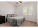 Comfortable carpeted bedroom with a ceiling fan, window and black nightstand at 7050 S Fawn Ave, Gilbert, AZ 85298
