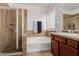 Main bathroom with tiled shower, soaking tub, and a vanity with a sink at 7050 S Fawn Ave, Gilbert, AZ 85298