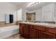 Main bathroom featuring double sinks, a soaking tub, and a tiled shower enclosure at 7050 S Fawn Ave, Gilbert, AZ 85298