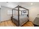 Bedroom with a four-poster bed, hardwood floors, and a window with shutters at 7430 E Chaparral Rd # A222, Scottsdale, AZ 85250