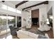 Living room featuring a modern fireplace with TV, exposed beams, a ceiling fan, and sliding glass doors at 7596 N Via De La Siesta --, Scottsdale, AZ 85258