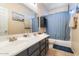 Bathroom featuring double sinks, dark cabinets, a large mirror and a bathtub with a shower at 838 E Nolan Pl, Chandler, AZ 85249