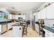 Kitchen with white cabinets, an island, and stainless steel appliances. Table visible in the background at 838 E Nolan Pl, Chandler, AZ 85249