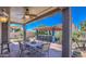 Outdoor kitchen, bar, and dining area under a covered patio with beautiful blue sky and lush greenery at 838 E Nolan Pl, Chandler, AZ 85249